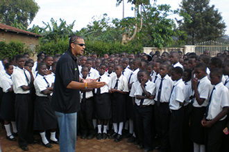 Myke Scholl conducting motivational assembly with High School youth in Uganda
